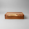 A rectangular wooden storage box with a hinged lid, featuring a rich reddish-brown wood body and a lighter natural wood inlay on the lid, set against a neutral gray background.