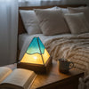 tiffany style pyramid lamp in amber and blue on a bedside table