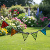 A stained glass arch suncatcher with multiple colorful triangular panes in blue, green, orange, red, and purple, suspended on a metal frame in front of a window.