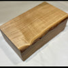 A rectangular wooden box with a live edge, showcasing a prominent natural grain on the top lid, photographed on a white fabric background.